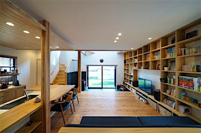 南北に長い敷地に合わせ、間口は小さく奥行きは長い設計。玄関から入ると、リビングとひとつながりの土間サロンの向こうに大きな掃き出し窓があり、その先の芝生の庭まで目線が抜ける。