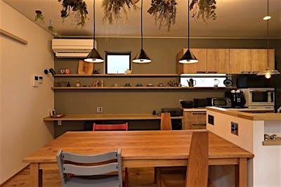 キッチンダイニングの壁はグレーのアクセントウォール。大きな飾り棚に、お気に入りの小物を並べて。