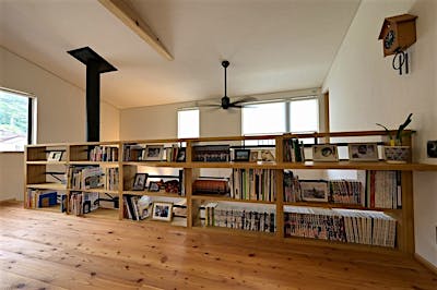 二階の共有スペースは、吹抜けに面した腰壁をオープンな本棚にした。背板をアイアンにし、目線が抜けることで、収納力と開放感を両立。