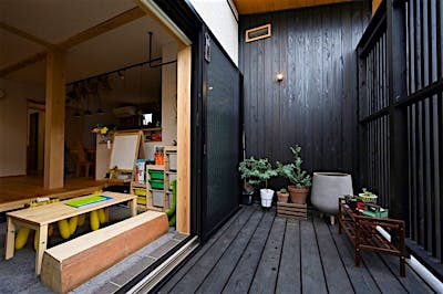 道路に面するウッドデッキは、縦格子を設けて目隠しをしつつ、風と光の通り道を確保。土間サロンの窓を開け放っても気兼ねなく過ごせる。