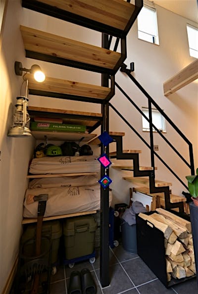 階段下はアウトドア用品や薪グッズを置けるオープンな収納空間。汚れを気にせずタフに使える。
