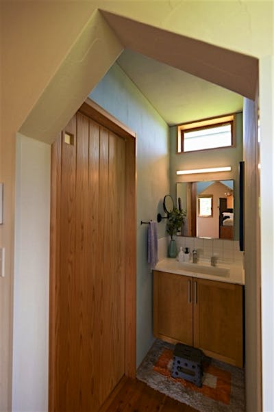 インテリアに馴染む、造作の洗面コーナー。三角形の入り口が遊び心をくすぐる。