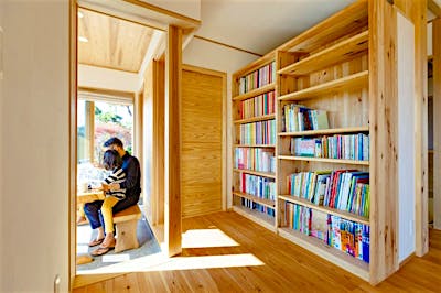 土間サロンとリビングの間に大きな本棚を設けました。子どもの絵本も仕事関係の本もここに集約でき、明るい土間サロンで読書ができます。すこし集中したいときには、本棚裏の書斎コーナーへ。