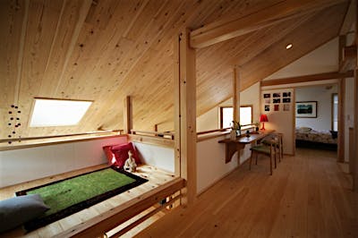 吹抜けにただようような「浮き床」スペースは、子どもたちのとっておきの遊び場に。天井は低いが、天窓と地窓で光をたっぷり浴びる空間に。