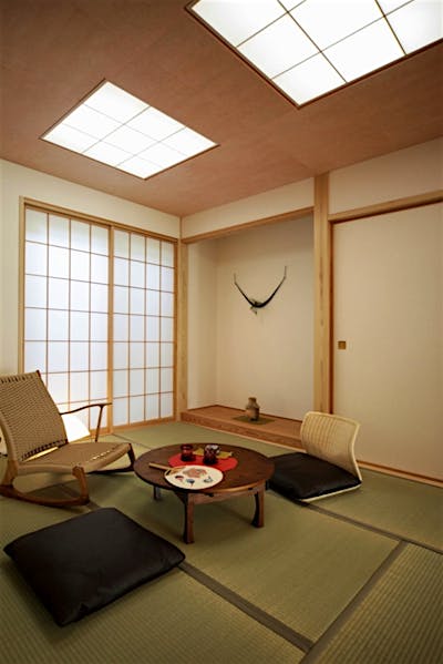 桜色の彩色和紙の天井が明るい印象の和室。障子戸を開くと中庭を望める。