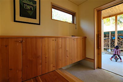 玄関に入ると、アトリエm4のカラマツ材の収納がお出迎え。シューズもたっぷり収納できる。