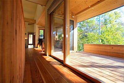 リビングダイニングと同程度の広さの屋根付きウッドデッキ。ウッドデッキへは、リビング、キッチン2方向からアクセスできる。どちらも掃き出し窓だから、屋内との一体感も一層増す。  