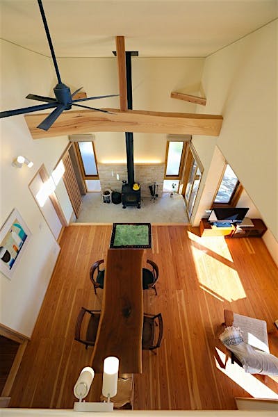 薪ストーブを据えた土間と、そこに真っすぐ繋がるリビングダイニング。全体が吹抜けになっているので空間の一体感が生まれている。