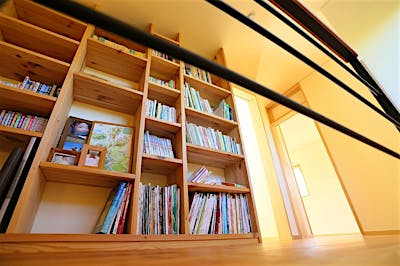 階段を登り切ると大きな本棚。お気に入りの本や家族の思い出が並ぶ。