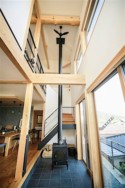 吹抜けに伸びる薪ストーブの煙突が、家じゅうにあたたかさを運ぶ。