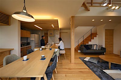 キッチンの下がり天井には板張りと間接照明を計画。空間のアクセントに。キッチンと横並びのダイニングは作業動線もバツグン。