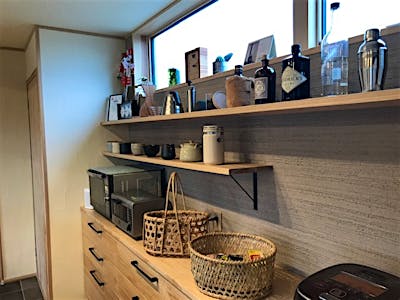 キッチンの背面側はジョリパッド仕上げで空間のアクセントに。お気に入りのツールをディスプレイ。