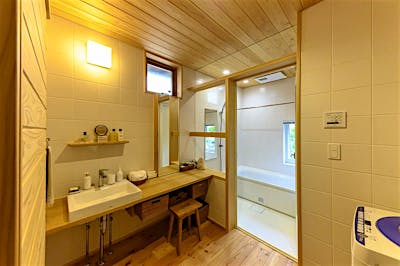 造作のバスルームと洗面脱衣室。大ぶりのホワイトタイルは、デザイン性とメンテナンス性を両立する。