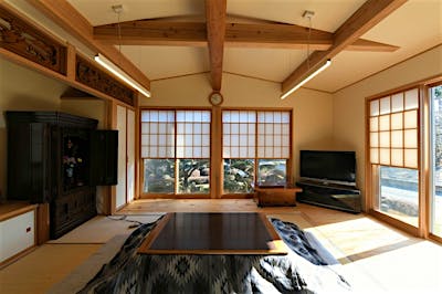 親世帯のリビング。ダイナミックに構造梁を見せる空間。雪見障子を上げれば、いつでも大切な庭を眺めることができる。