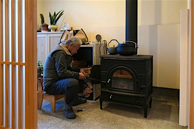 土間サロンに据えた薪ストーブの前は、お父さんの特等席。薪をくべ、火の番をしながら芯からあったまる。お父さんの座る椅子は、仲良くなった大工さんからのプレゼント。