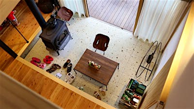 フラットにつなげた土間サロンとウッドデッキで、ソトとの行き来がもっと自由になる。約5畳の土間サロンは大谷石仕上げ。 