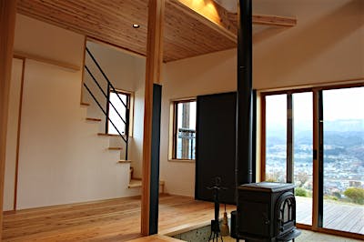 薪ストーブのブラックと、階段手摺のアイアンのブラックが空間を引き締める。