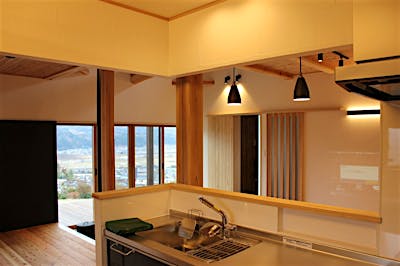 キッチンから1階を見渡すことができる。土間サロンの奥に広がる景色もバッチリ見通せる。