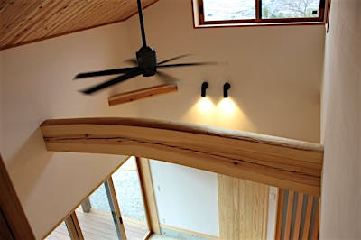 シーリングファンやスポットライトもブラックで統一。吹抜けに渡る立派な太鼓梁が、K様邸のシンボルに。