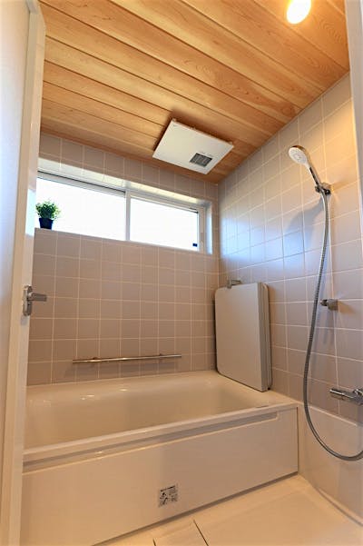 スタイリッシュなタイル貼りのハーフバス。天井の板張りで木のぬくもりも感じられる。