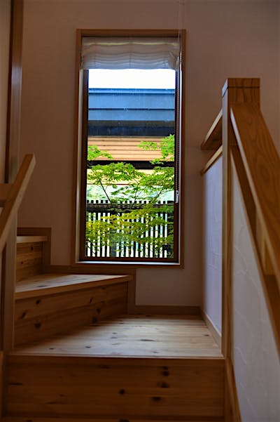 階段途中にはピクチャーウィンドウを設けた。シンボルツリーが綺麗に見える。
