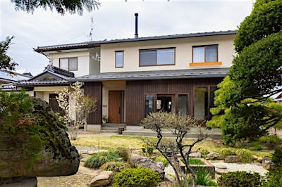 母屋の一部を解体し、横並びに新築。落ち着いた外観デザインが周囲の建物や歴史ある庭と調和する。