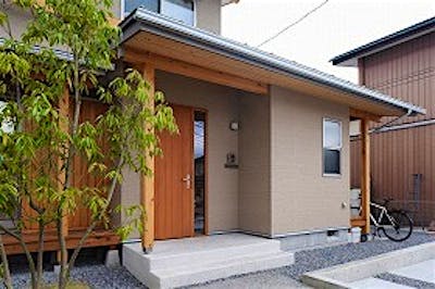 玄関ドアは木製の造作ドア。温もりある佇まいが家族を出迎える。