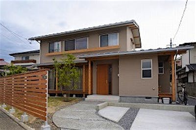 緩やかな三寸勾配の切妻屋根と、高さを抑えたスマートな外観に常緑樹のグリーンが映える。