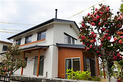 シンプルな切妻屋根の外観。玄関と土間サロンを下屋でおさめ、外観のアクセントとした。