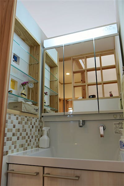 システムの洗面台でお手入れラクラク。壁をモザイクタイルと造作棚にすることで、ぐんとお洒落な洗面コーナーに。