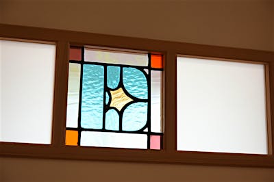 子ども室の建具にはめこんだのは、3兄弟のイニシャルがモチーフの作品。デザインも色合いも家族皆で一緒に決めた、思い出の一品。