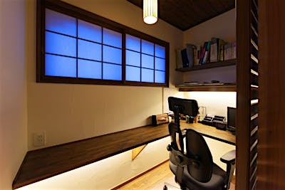 ご主人様こだわりの書斎コーナー。シックな色味のカウンターや建具、間接照明も大人の空間を演出する。