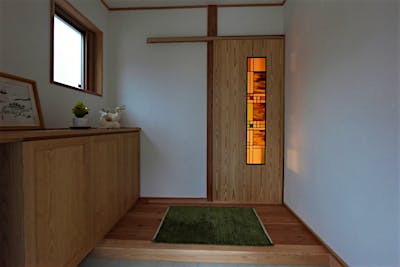 玄関を入ると框戸から柔らかい光が漏れる。大きなステンドグラスはご主人様の自作のもの。デザインから作業まで、一人で行った。