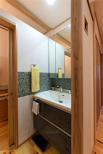 洗面コーナーはお気に入りのタイルで彩った。システムの洗面化粧台もこだわりのデザインに。