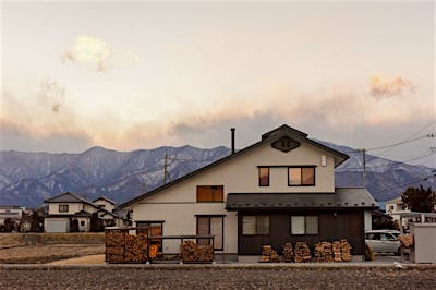 北アルプスの山並みに沿う、南に葺き下ろした大屋根の外観。黒のアクセントカラーで和モダンの趣に。