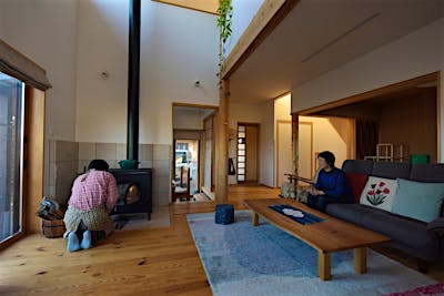 薪ストーブの火入れはご主人担当。マイエプロンがお似合い！