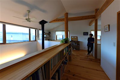 吹き抜けに面した腰壁前面に本棚を造り付け。カウンターの用途にもなり、使い勝手が良い。