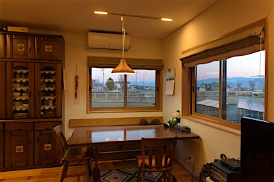 壁付ベンチのあるダイニングは二面に窓があり、ワイドな開口から東の山並みを楽しめる。
