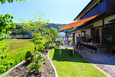 ウッドデッキ上にタープを張り木陰をつくれば、夏の暑い日でも庭暮らしを楽しめる。