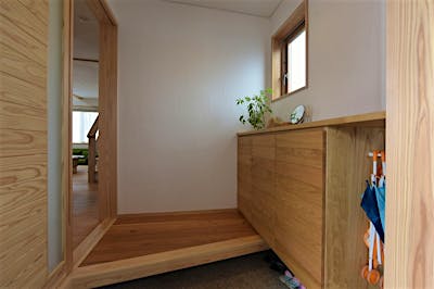 玄関ホールもシンプルなつくりに。シンプルだからこそ、木製家具の質感が際立つ。