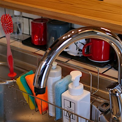 奥様のこだわりポイントのひとつ。シンク前にちょっとした収納スペースを配置することで、リビング側にごちゃごちゃしたものが見えずにスッキリできます。普段よく使うコップを置いておくのも便利です！