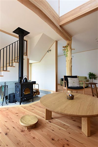 薪ストーブ前には栗材の円卓を。ストーブの輻射熱で無垢床がぽかぽかになるから、座の暮らしが気持ちよい。