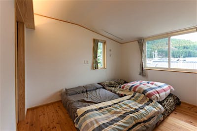 6畳の寝室。屋根形状に合わせて斜天井に。天井の低さが落ち着きを生む。