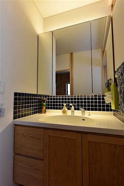 洗面化粧台はブラックタイルでスタイリッシュに。トップは人造大理石でお手入れラクラク。