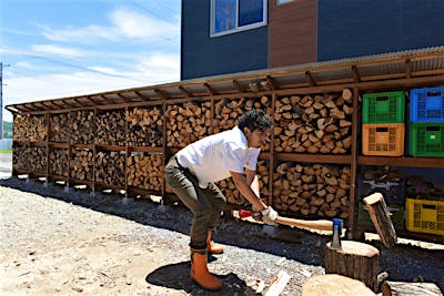 敷地外周をぐるりと囲む薪小屋もすべてお手製。区分けした薪材と収穫コンテナに収納した焚き付け材が見栄えも良い。