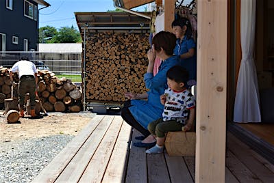 薪作業をするご主人様の隣で、奥様は庭の手入れをしたり、子供たちは砂利遊びをしたり。ちょっと疲れたらウッドデッキでお茶や、時にはランチも。外とつながる暮らしを存分に楽しむ。