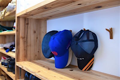 玄関収納内の帽子掛けには、庭のイチイの木の枝を利用した。小さな部分にも思い入れがある。