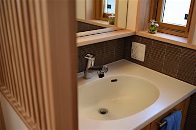 造作洗面も、トップが人工大理石、壁の立ち上がりもタイルなので水撥ねも気にならない。デザインと機能性を兼ね備えた。