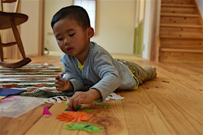 冬でも赤松の床にごろりと寝転んであそぶ。無垢の木肌が薪ストーブのぬくもりを含み、なんとも心地よい。