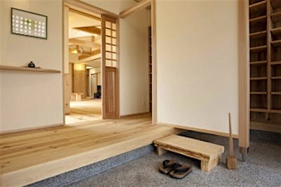 住まいの顔となる玄関はしつらえにもこだわり、季節に合わせて飾り変えられるピクチャーレールと飾り棚を設けた。目隠し壁の向こうに下足入れを設け、見た目にもすっきりと。